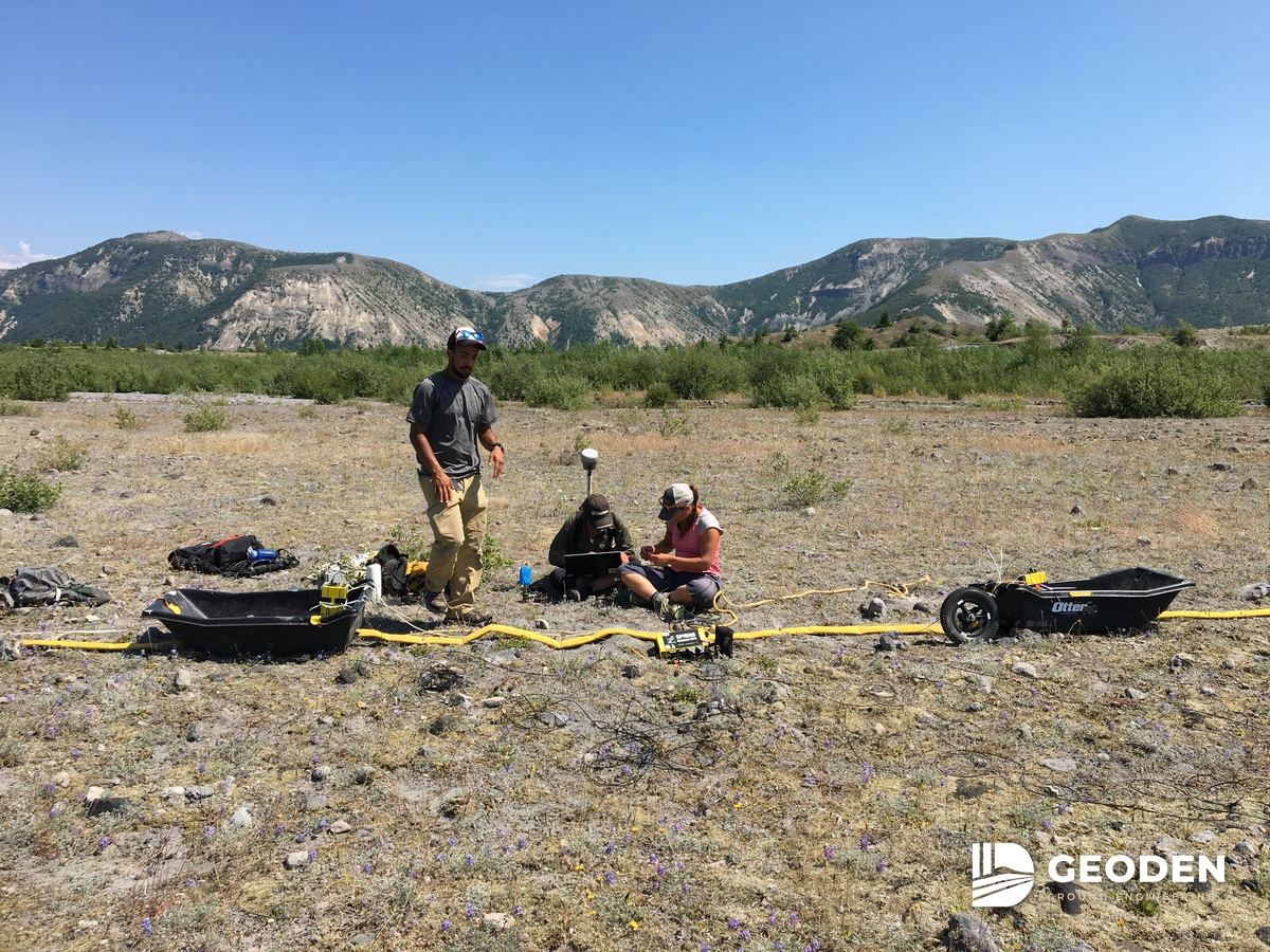 Survey crew recording a geophysical line laid out across open ground